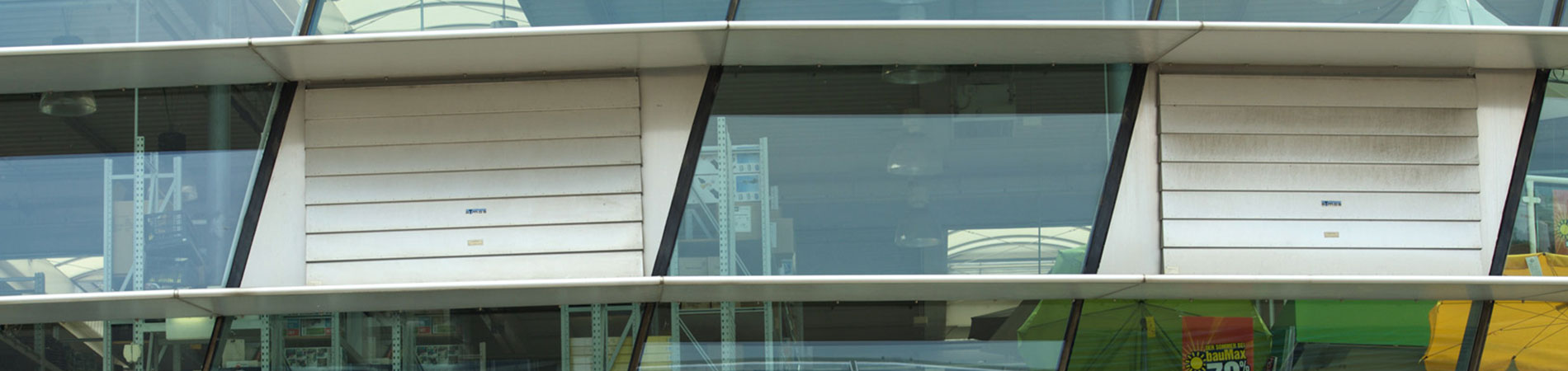 Lamellenlüfter vertikal in Glasfassade integriert